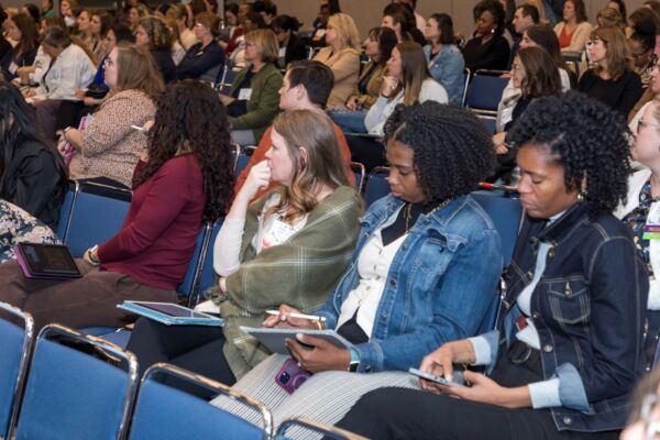 Group of conference attendees listening to a speaker